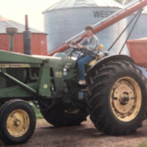 Carla Antichow driving a tractor while growing up on her family’s farm.