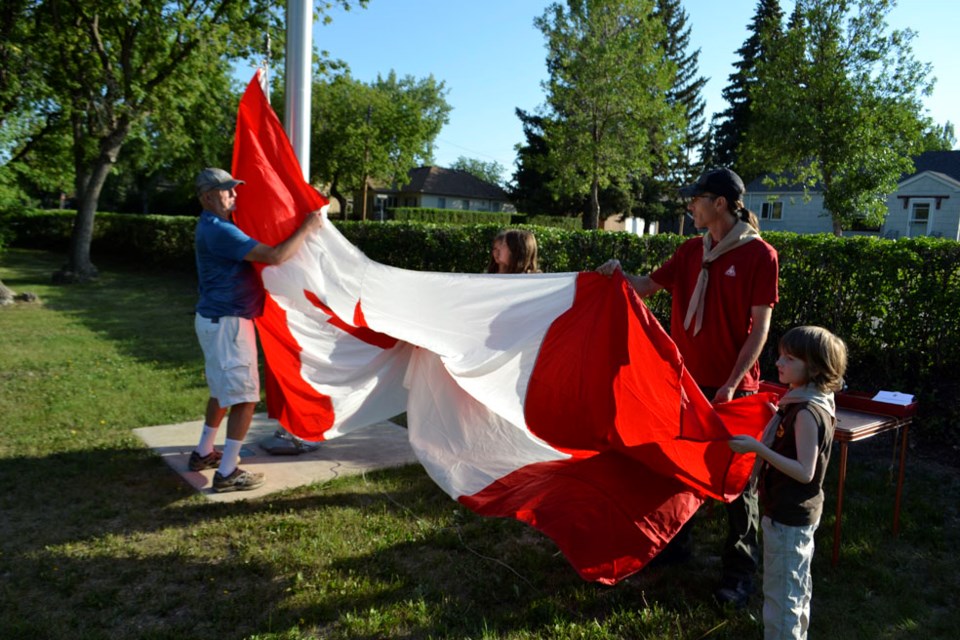 First Virden Scouts Leader David Roach and his son Nicholas assist Kel Smith of the Virden Canada Day Celebrations Committee to raise the Canada Flag in Victoria Park in the morning of July 1. In the background, Hailey and MacKenzie Hayden helped out.