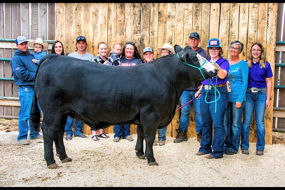 The Gabrielle family poses with steer that was donated in Rick’s memory (l-r): Bobby, Lane, Baylee, Justin, Jackie, Blake, Carla, Recklan, Cooper, Ryan, Jayda, Diane and Myla.