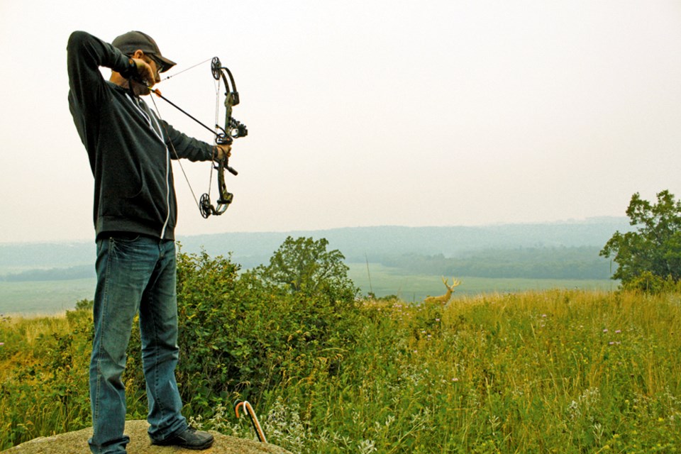 Cody Denbow aims at a mule deer target overlooking the Assiniboine Valley.