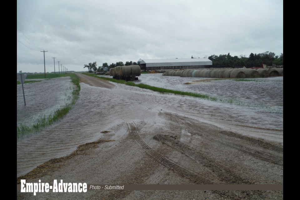 Water flows over the municipal road. Photographed in 2014, Vince Heaman’s bale yard is flooded on his farm at 32-11-26 W. Heaman says water has been an ongoing problem since 1996.