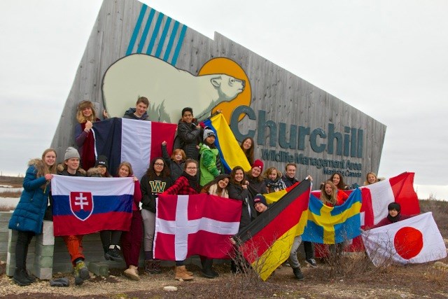 International students pose in front of the Churchill Wildlife Management Area welcome sign.