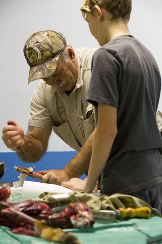 Manitoba Trappers’ Association President Lane Boles teaches a potential trapper how to clean a hide