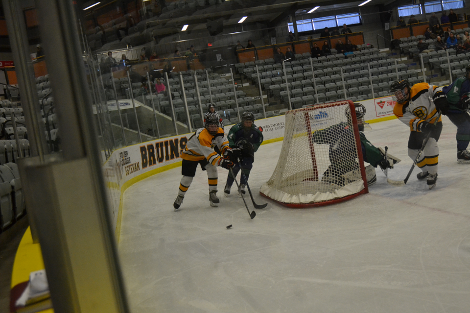 Colby Cuddington and a Swift Current Broncos opponent chase after the puck in Game 1 of the South Sa