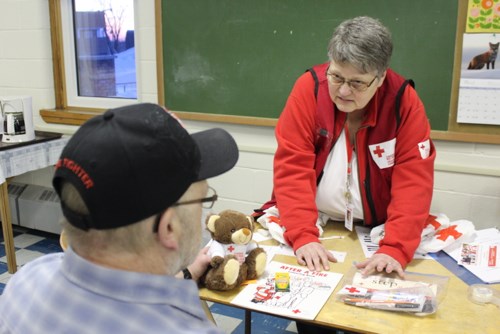 Bev Erickson shows Cranberry Portage Fire Cpt. Lori Neufeld the contents of a Red Cross PDA kit.