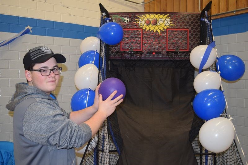 Kade Wishnevetski encouraged players to “slam dunk” a basketball into a net at one of the booths at the Winter Carnival.