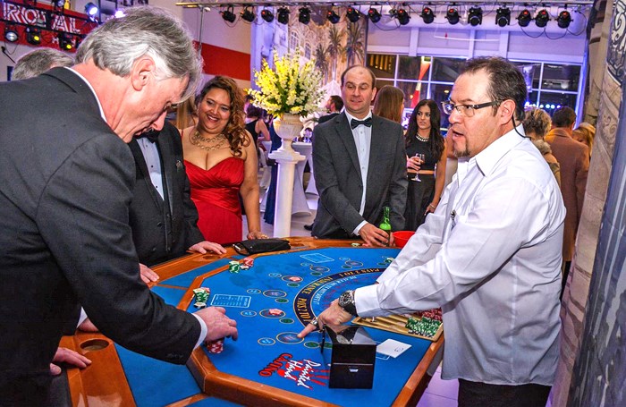 Mervin Liard, left, gets ready to place a bet while dealer Will McKenzie explains the game.