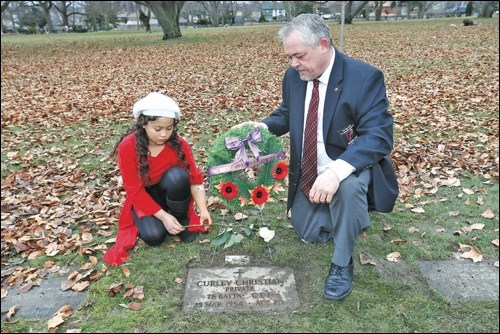 Rob Larman and Tiffany Ross lay a rose at the grave of Curley Christian to mark the 100th anniversary of the Battle of Vimy Ridge and pay tribute to the war amputee veterans who started The War Amps.