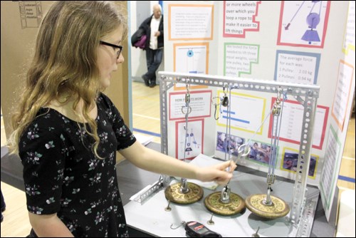 Emily Holmen, a grade 4 student from The Pas, demonstrates her project, Pulleys. Emily’s project showed how pulleys can lift a series of weights. - PHOTO BY ERIC WESTHAVER