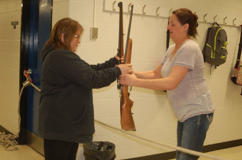 Roxanne Fedorchuk, left, and Shannon Prestie displayed the proper technique for crossing a fence with a firearm.