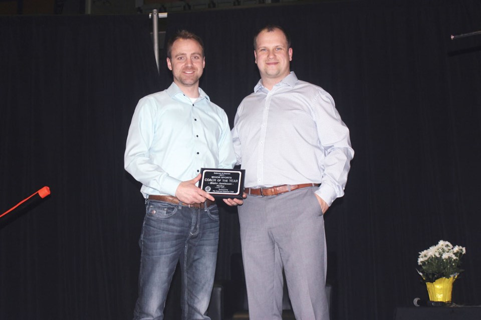 Blake Jamieson, left, accepts the Volunteer Coach of the Year Award from Bruins head coach and general manager Chris Lewgood.