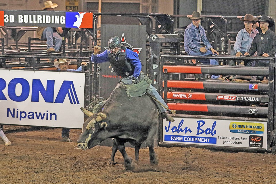 Jared Parsonage of Maple Creek rides a bull in the second round at the Nipawin RONA PBR. He was the only one to stay on the bull that round, allowing him to win the competition. Review Photo/Devan C. Tasa