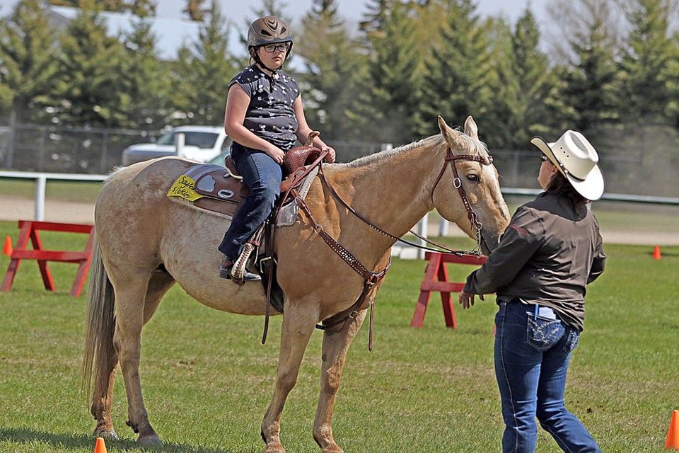 Saylor Teale, left, receives tips to improve her riding at the 4-H Equine Camp in Melfort May 20 and 21. Review Photo/Devan C. Tasa