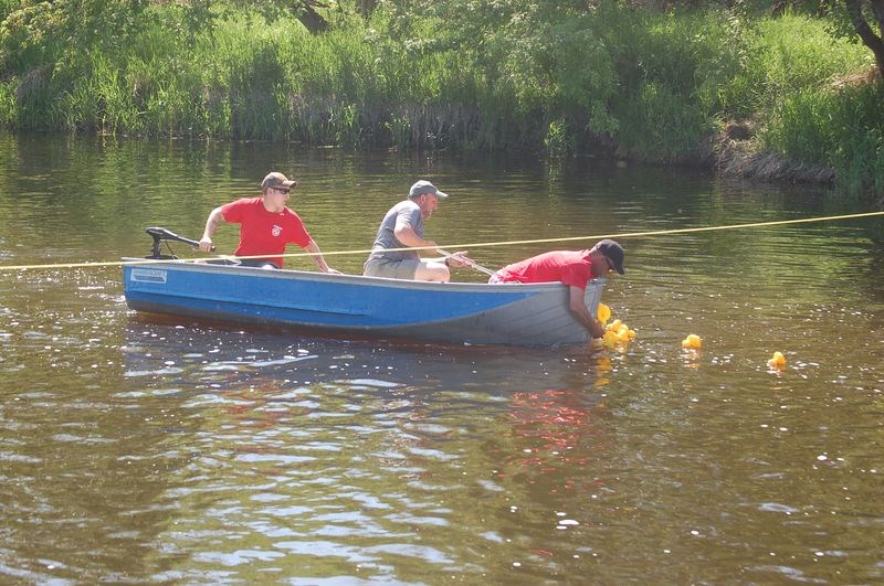 Tyler Blender, left, Daniel Wasylenchuk and Craig Folk caught plastic ducks as they floated over the finish line.