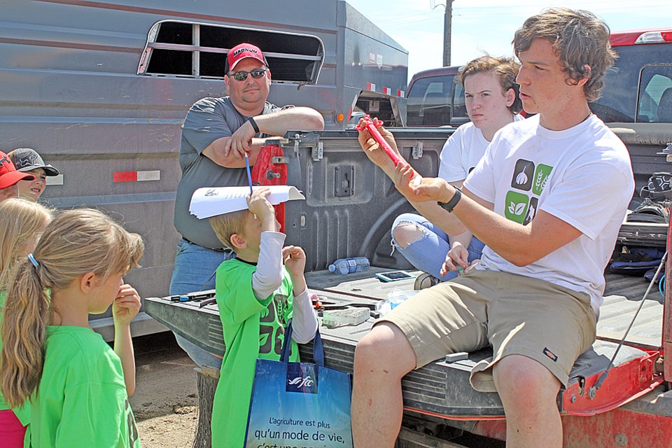 The Burger and Fries Farm at Melfort's Gateway Veterinary Services June 7 was an opportunity for local elementary students to learn where their food comes from. Here, they learn how cattle receive pills. Review Photo/Devan C. Tasa
