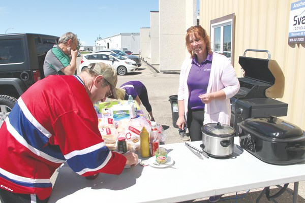 Cap-It held its grand opening, and part of that grand opening saw the new truck accessory store support community groups. They hosted a community barbecue for Big Brothers Big Sisters of Yorkton and Area, giving people the chance to have a burger for a good cause. Pictured, Susan Kellock with BBBS serves some hungry customers.