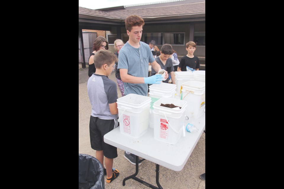 Rhys Maksimow distributes materials to other students at Yorkdale to build a water filter on a third-world budget.