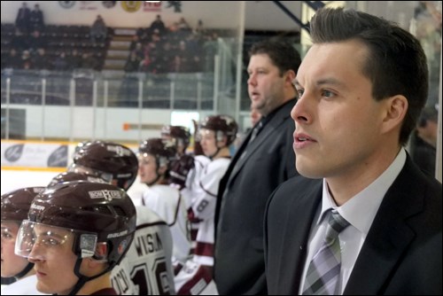 Flin Flon Bomber assistant coach Garry Childerhose stands behind the team's bench in the Whitney For