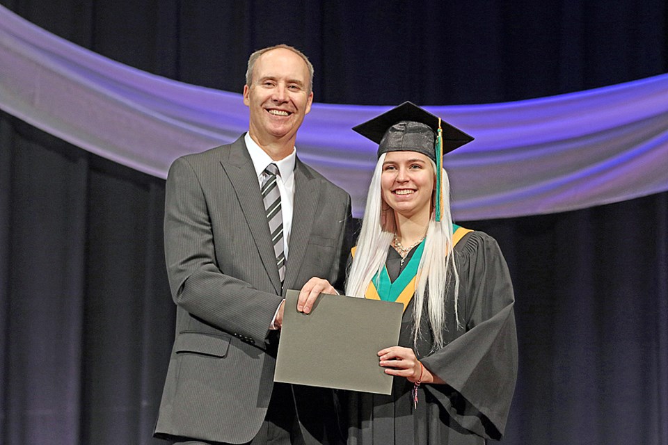McKenna Beuker, right, receives her high school certificate from Jerry Heffernan, Melfort Unit Comprehensive Collegiate's principal, at the school graduation ceremony June 29. Review Photo/Devan C. Tasa