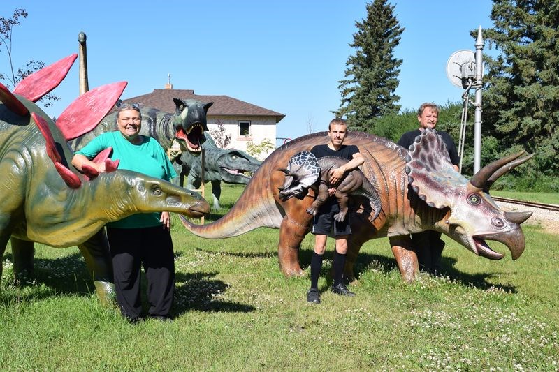 Jordan Huebert and his parents Wally and Mary have fibreglass dinosaurs in their yard and enjoy showing them to visitors.