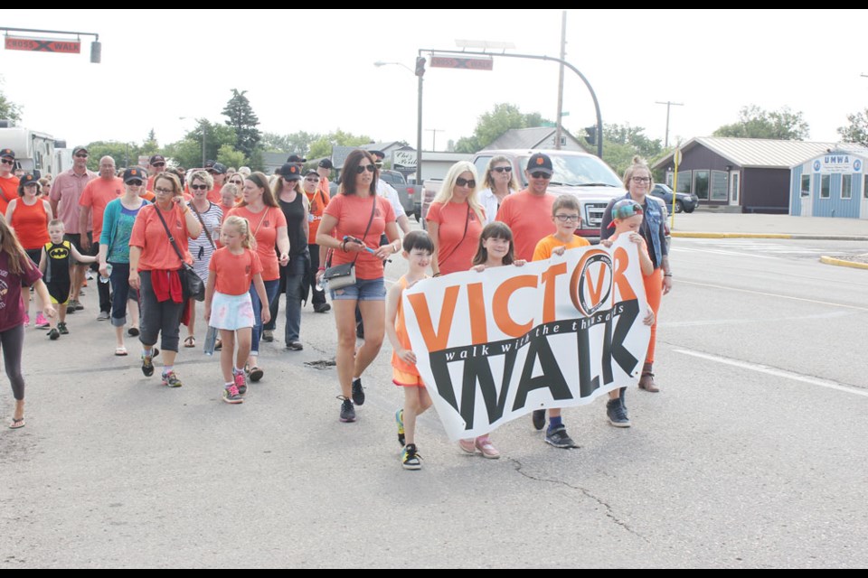 Participants in the Victor Walk paraded down Fourth Street Friday morning. Most of them sported orange t-shirts, which is the colour of the Victor Walk.