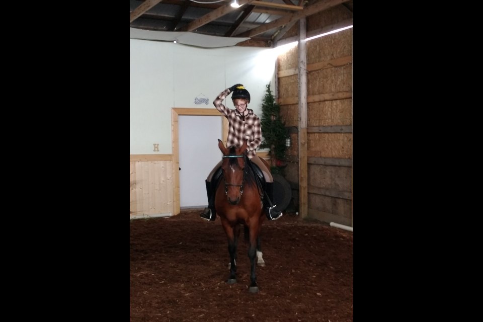 Sophie Anderson trying to balance a bean bag on her helmet while riding.