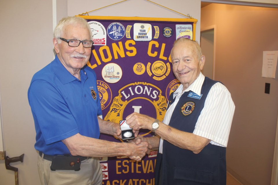 John Johnson, left, accepted a commemorative coin from Allan Senchuk to mark Johnson’s 50 years of service with the Estevan Lions Club.