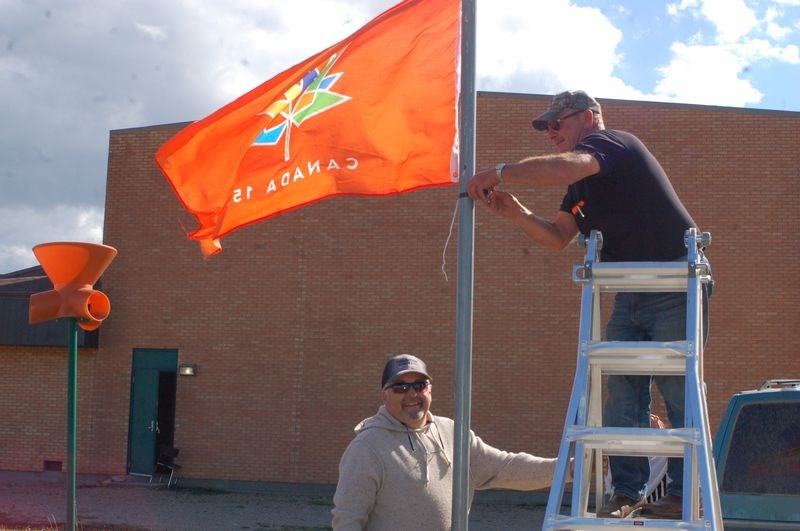 Larry Buchinski, left, and Brad Romanchuk hung the Canada 150 flag.