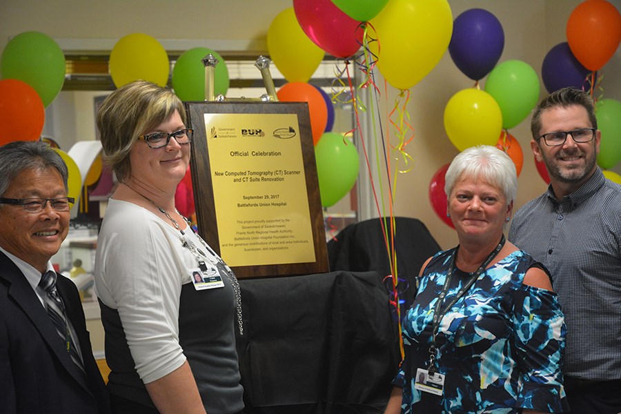 Prairie North Health Region CEO David Fan, medical imaging manager Colais Fransoo, director of medical imaging Cheryl Mitchell, and Battlefords Union Hospital Foundation chairperson Jay Crockett unveil a new plaque commemorating the BUH's new CT scanner.