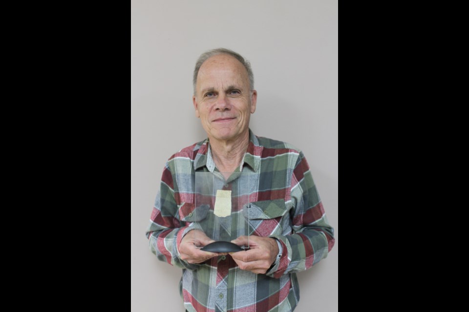 Historian Dennis Strom holds up one of the few remaining pieces of the balloon bomb – also called a fugo – that was found near Mari Lake in 1945. - PHOTO BY ERIC WESTHAVER