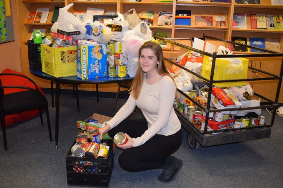 Julianna Raabel, a member of the KCI’s Free the Children group participated in a We Scare Hunger campaign, collecting non-perishable foods on Halloween which will be divided into hampers and donated to families of KCI students. Raabel was photographed last week with the piles of food that had been collected.
