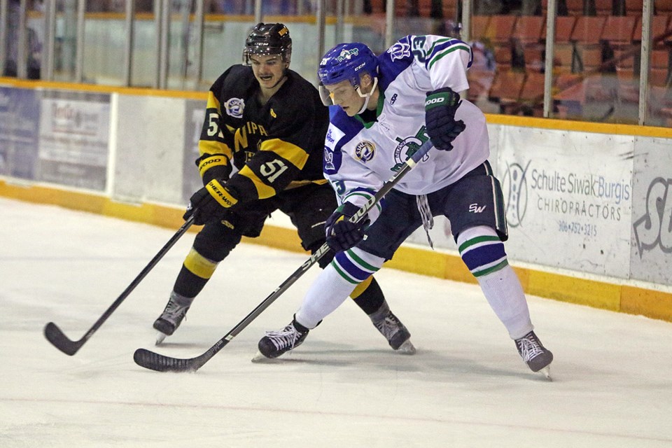 Jeremy Bisson of the Nipawin Hawks and Boedy Donald of the Melfort Mustangs fight for control of the puck during the game in Melfort Nov. 10. Review Photo/Devan C. Tasa
