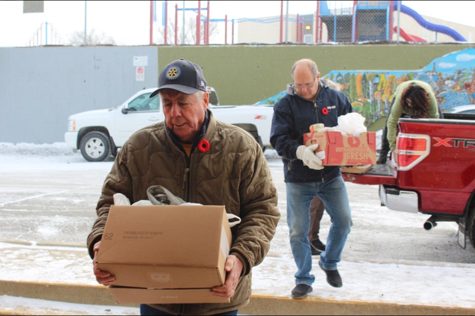 Rotarians Glenn Smith and Dennis Whitbread and Lord’s Bounty Food Bank vice-chair Alison Dallas haul food into the new food bank location on Hiawatha Avenue on Nov. 2. Several local businesses and groups, including the Flin Flon School Division and the Rotary Club, donated hundreds of items as part of the food bank’s annual food drive. Renovations at the site are set to wrap up in the coming weeks. - PHOTO BY ERIC WESTHAVER