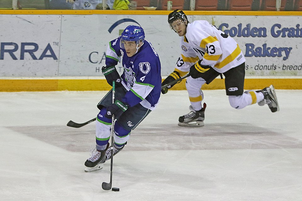 Adam Hergott of the Mustangs skates the puck away from Grant Baetsen of the Hawks during the game in Melfort Dec. 1. Review Photo/Devan C. Tasa