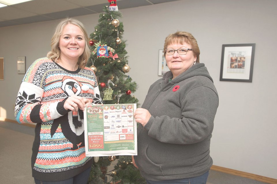 From left, Estevan Mercury Publications sales manager Deanna Tarnes holds up a copy of the Estevan Mercury Bingo poster contest with grand prize winner Brenda Turnbull.