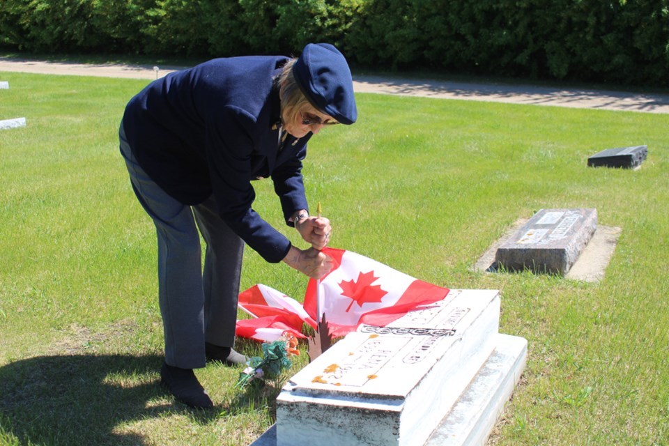 The ground may have been hard but that did not stop Betty Hall from placing a Canadian Flag at the grave site of her mother and father in law during Decoration Day on June 4. photo by Christopher Lee