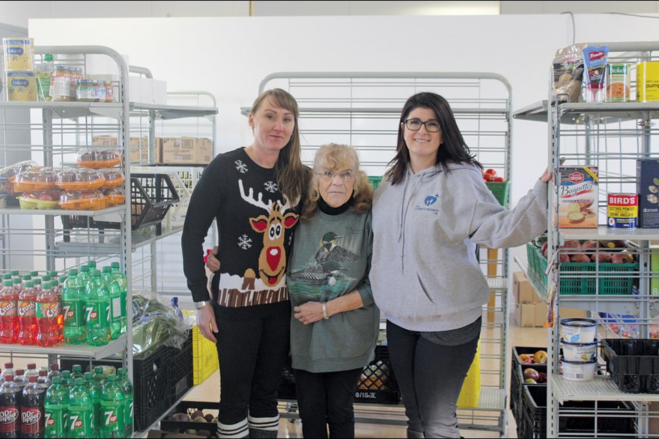 Food bank executive members Tanisha Weseen, Charlotte McNey and Alison Dallas-Funk stand in the new headquarters of the Lord’s Bounty Food Bank. The food bank opened its new location on Hiawatha Avenue on Dec. 19. - PHOTO BY ERIC WESTHAVER