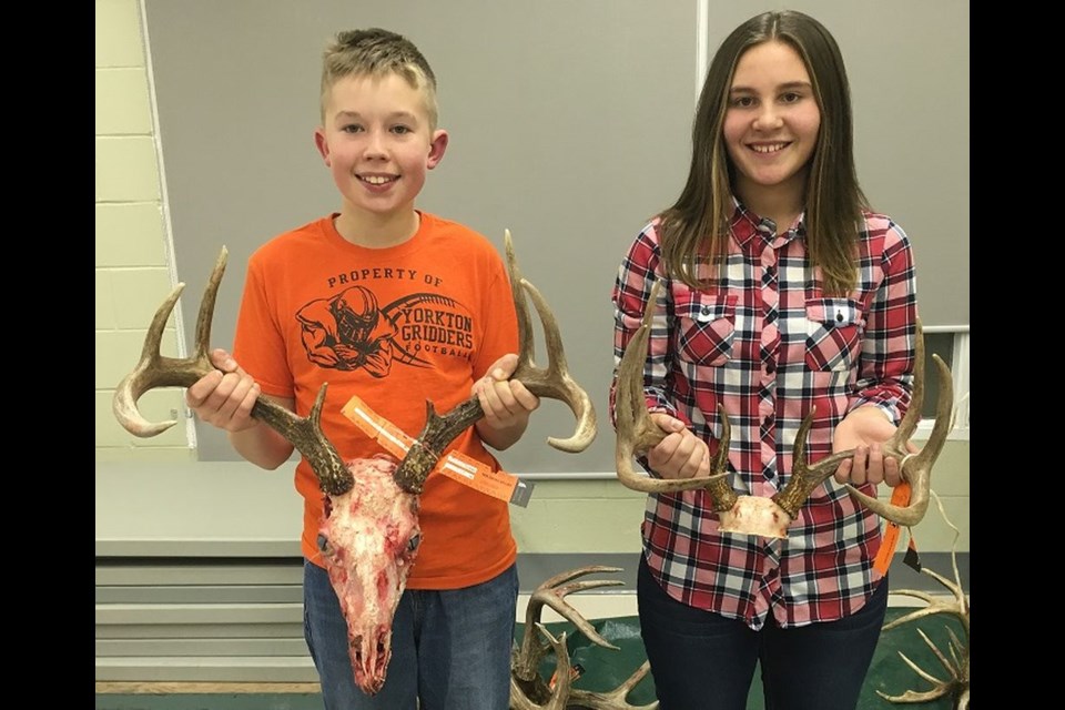 Junior hunters Everett Paley (left) and Kailey Sleeva brought in their white-tailed deer antler entries for measuring.