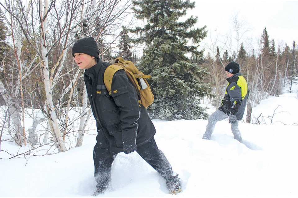 Ruth Betts Community School students Joel Fidler and Jordan Sevold hike through the snow as part of the Flin Flon School Division’s outdoor education class. - PHOTO BY ERIC WESTHAVER