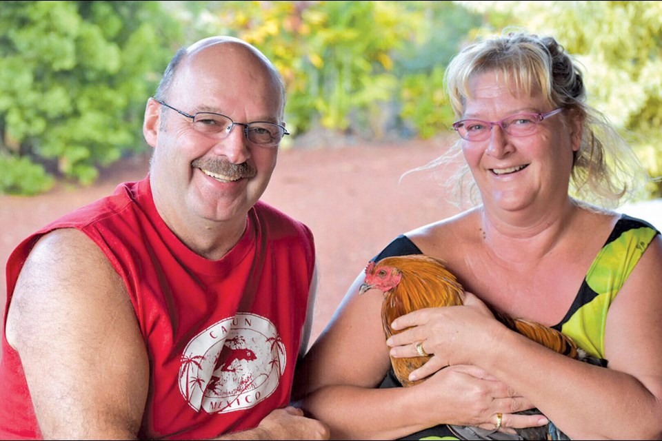 Michel Dupont and Lenna Gowenlock with their pet rooster, Rex, at their second home in Hawaii. Dupont and Gowenlock both received a text alert on Jan. 13 saying that a nuclear missile would hit Hawaii — a message that was later found to be sent in error. - SUBMITTED PHOTO