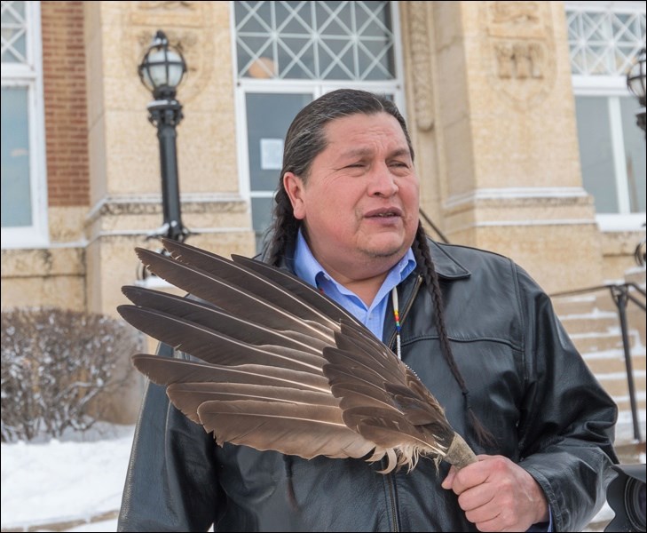 Alvin Baptiste, holding an eagle feather, representing justice.