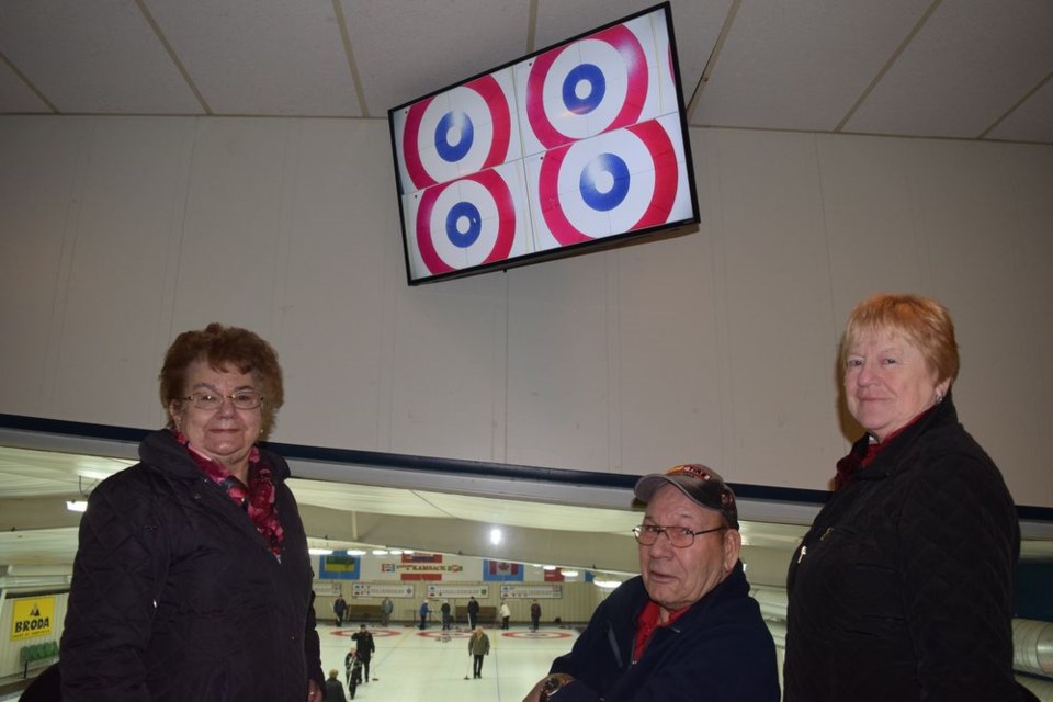 Shortly before Christmas, closed-circuit television cameras were placed over each of the four houses at the far side of the curling rink at the Broda Sportsplex. The cameras allow members of the mezzanine audience to watch two monitors, divided into four scenes, as the rocks stop on the rings. At the viewing area on January 25, from left, were: Elaine Krasnikoff, Albert Rose and Verna Swetlikoff of The Pas.