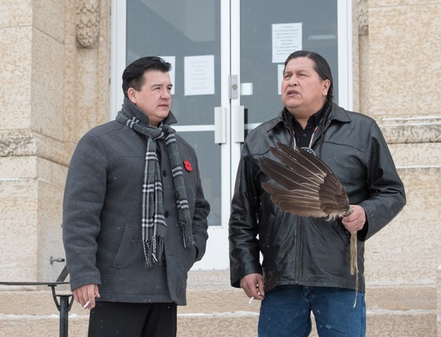 Bobby Cameron, FSIN chief, talk with Alvin Baptiste, uncle of Colten Boushie, outside the courthouse at lunch break last week. Baptiste attends court daily with an eagle-feathered symbol of justice.