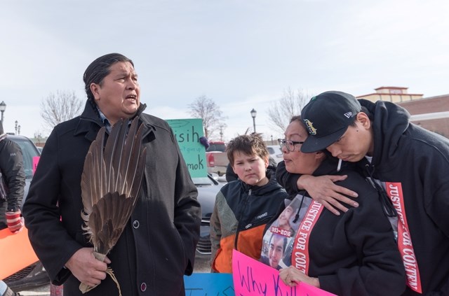 Jace Baptiste hugs his mom, Debbie, while his uncle, Alvin Baptiste displays an eagle feather.