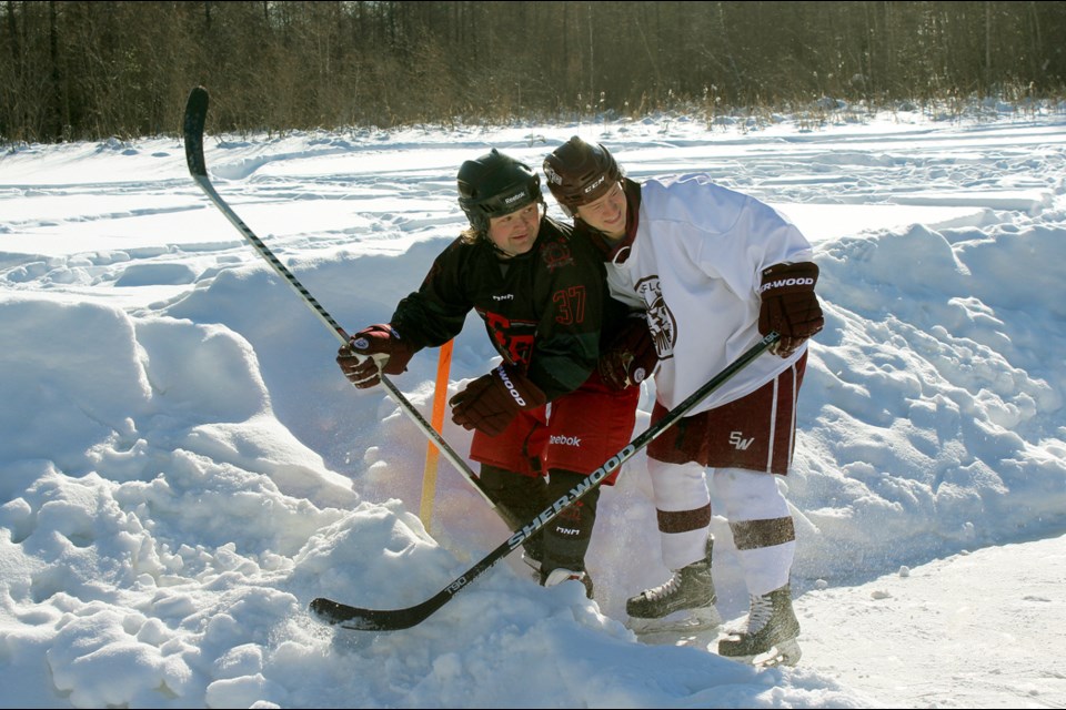 Damian Dominey and Flin Flon Bomber Caleb Moretz dig for the puck in a snowbank. - PHOTO BY ERIC WESTHAVER