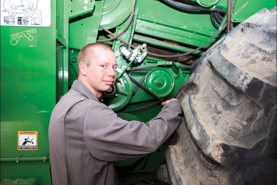 Mechanic Keagan Fieber works on a customer’s combine as a part of spring maintenance so it is ready to go for seeding season. Photo by William Acri