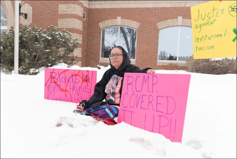 Debbie Baptiste sits in front of courthouse amidst the signs she brought.