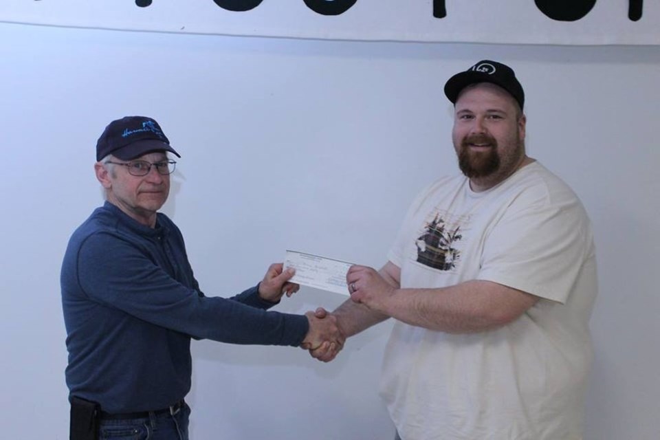 Barry Engdahl, right, of Saskatoon was presented with the most money raised in hands during the Lintlaw 75 snowmobile derby on March 3. Ron George, left, made the presentation.