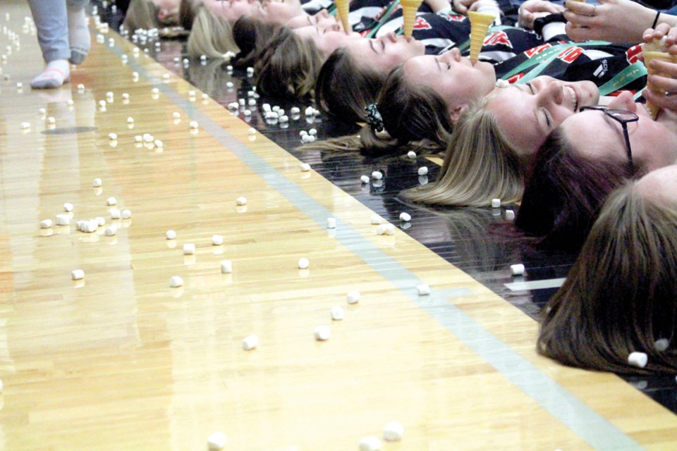 Marshmallows lined the floor of the Middle Lake gym on March 28. After celebrating both the boys’ and girls’ provincial basketball gold medals, the players took some time to play games with their younger school mates. The game saw the players lay on the floor with an ice cream cone in their mouths as younger students threw marshmallows, hoping to score more “baskets” than anyone else. photo by Christopher Lee