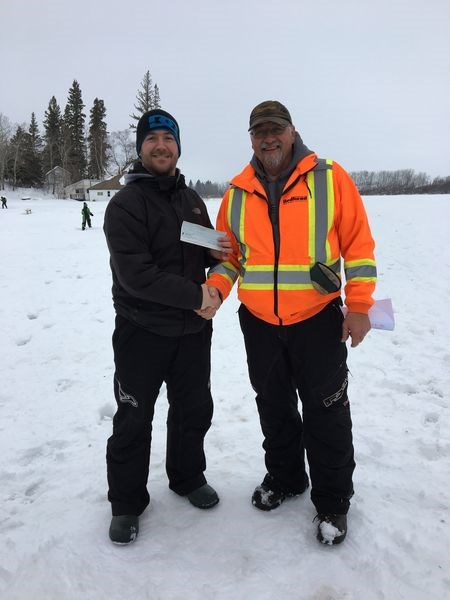 Gary Jakubowski, right, presented Shane Nelson with the award for the largest fish caught at the Nelson Lake ice fishing derby on March 24. The northern pike measured 21 and 5/8 inches.